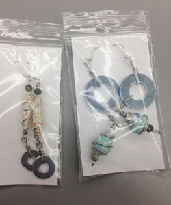 clear packages of earrings made of repurposed materials